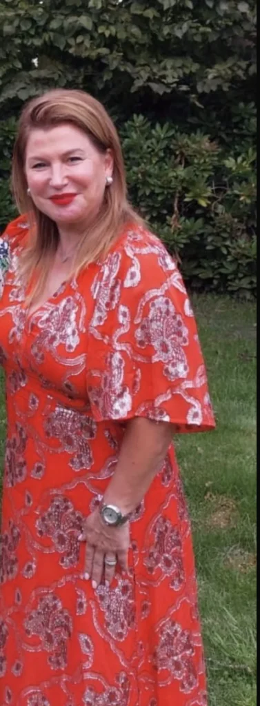 Ilse, klant van Focus-On, in een rode jurk in de tuin