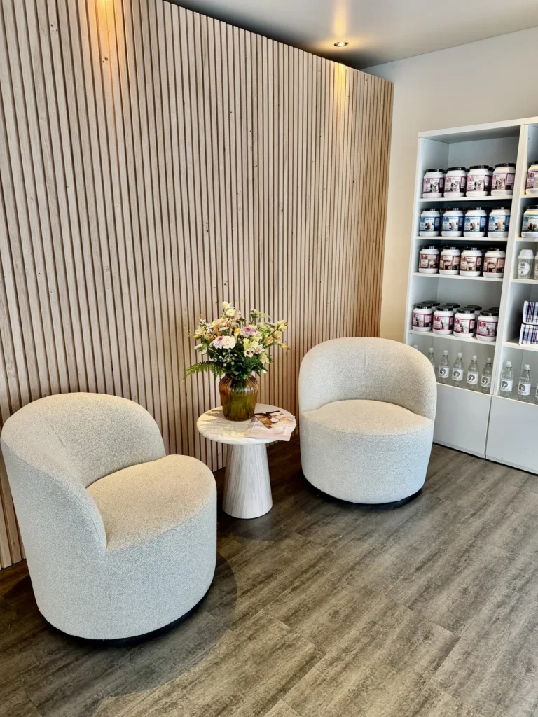 Warme ontvangstruimte met fauteuils, bloemen en houten wand bij Focus-On